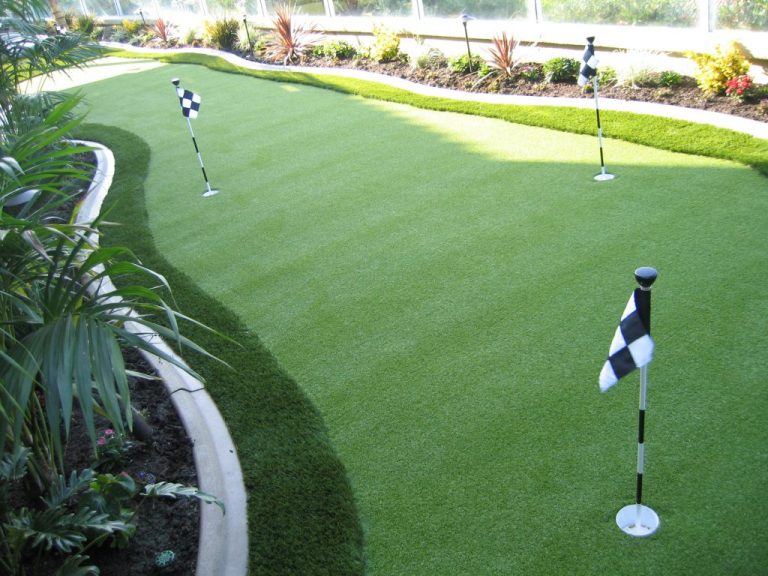 Backyard putting green with flags beside a lawn