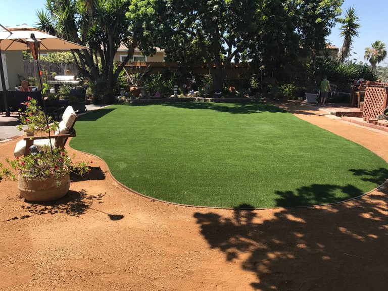 Curved artificial grass lawn set into a decomposed granite yard
