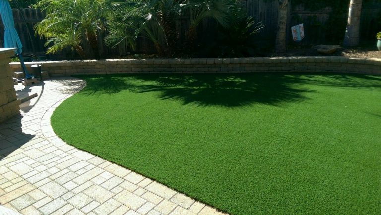 Artificial lawn bordered by a paver edge and garden bed