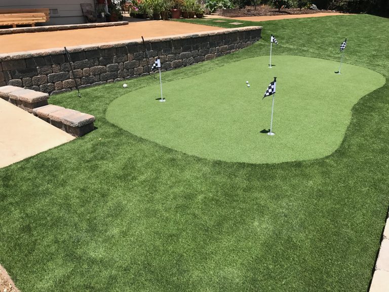 Putting green with flags set into a larger artificial lawn