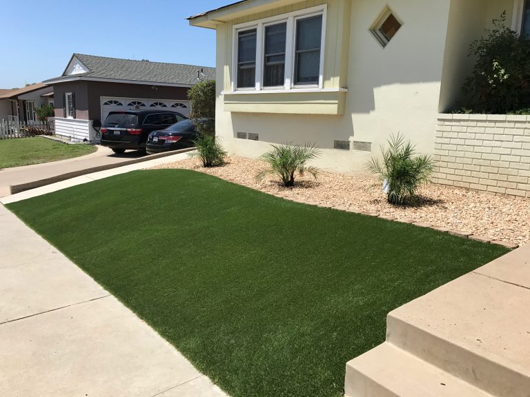 Front lawn replaced with artificial grass beside a driveway