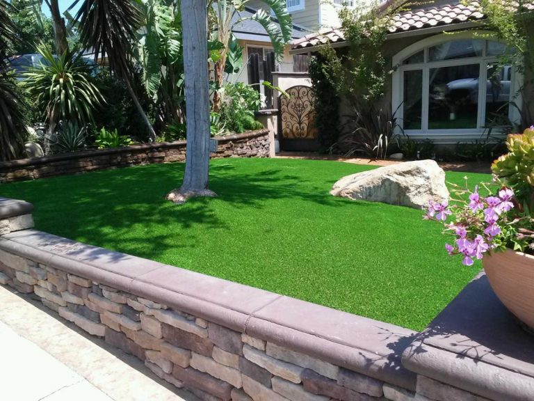 Raised artificial lawn behind a stone retaining wall