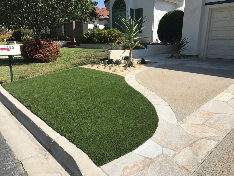 Curved front yard lawn of synthetic turf beside a concrete path