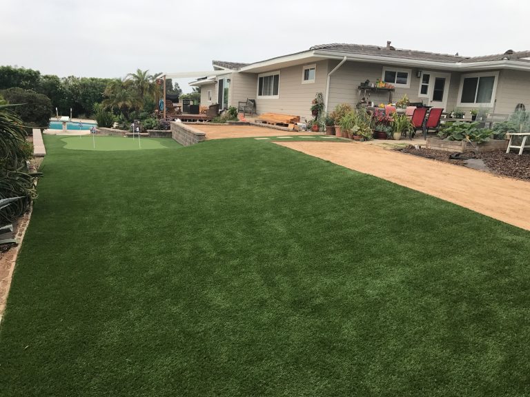 Front lawn of artificial grass along a gravel driveway