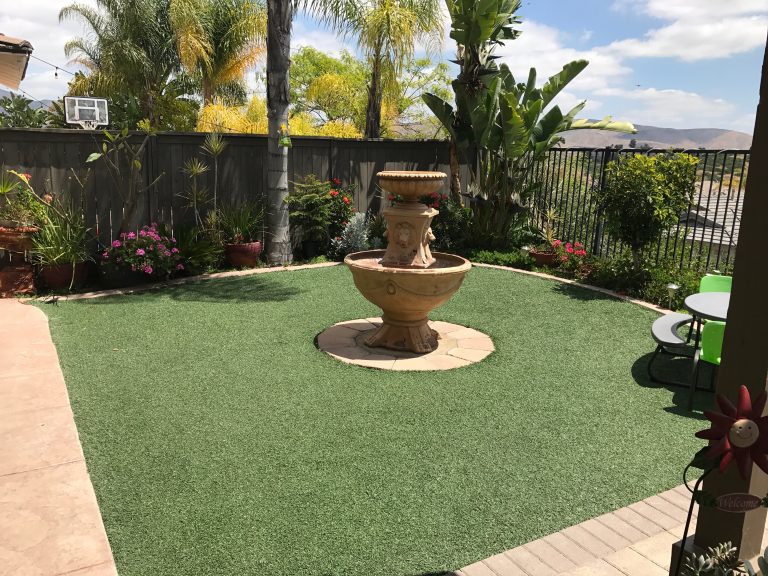 Artificial grass lawn around a garden fountain