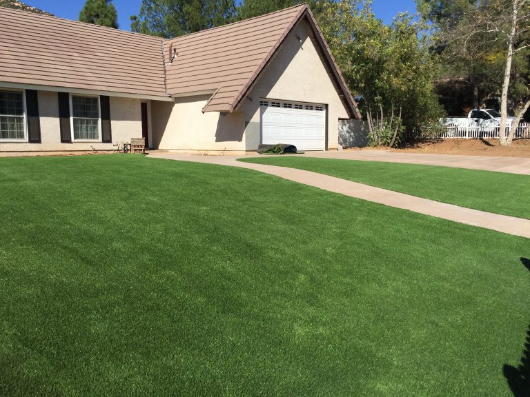 Home with a freshly installed artificial grass front lawn