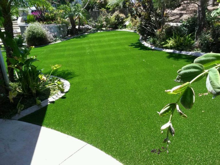 Synthetic lawn curving through a landscaped backyard