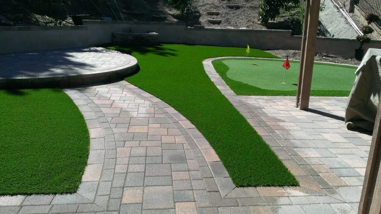 Putting green and artificial lawn beside a curved paver path