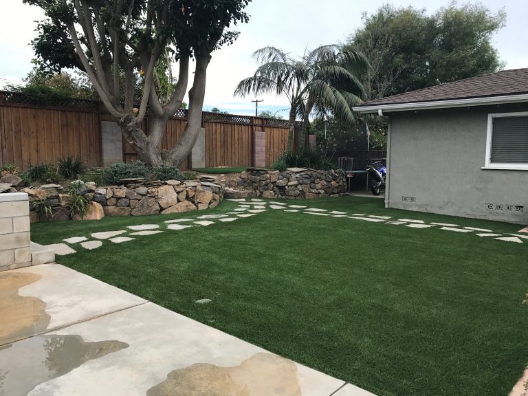 Front lawn of artificial grass with stepping stones